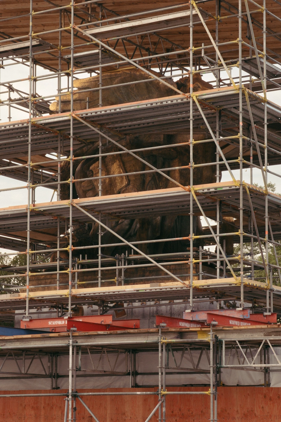 Scaffolding and fencing surround one of the Arts of Peace sculptures