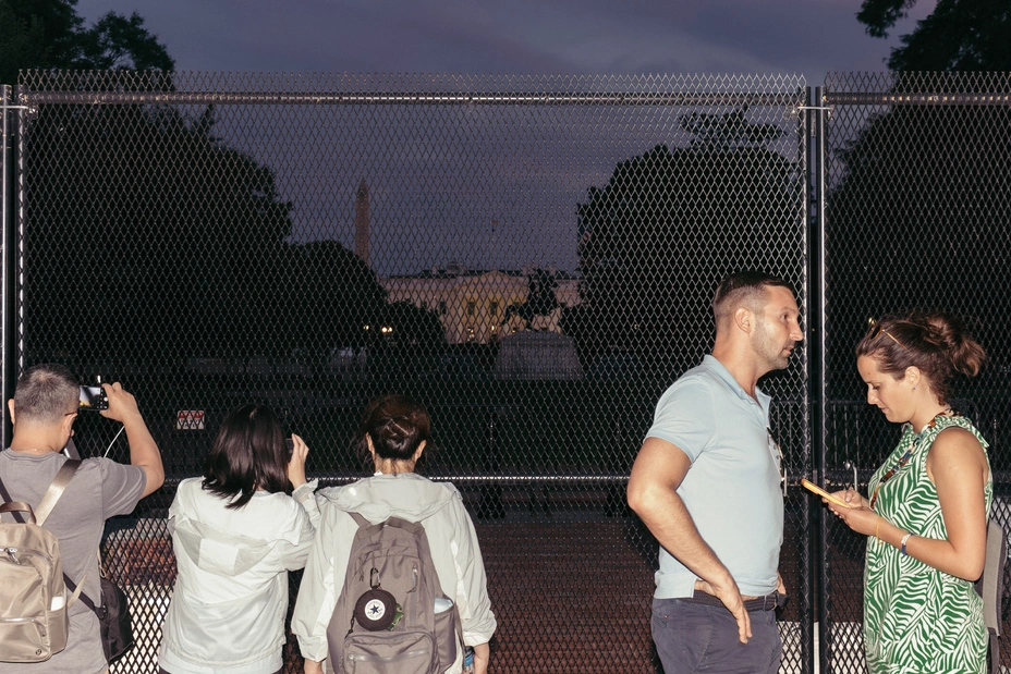 Visitors look at the White House from behind fencing in Lafayette Square on June 25